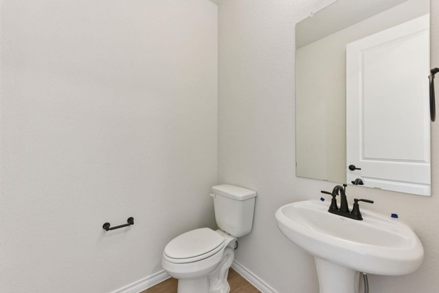 Half bath with toilet and baseboards