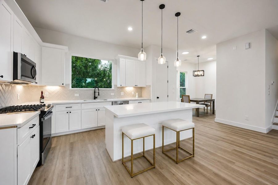The beautiful kitchen features a gas range, generous island seating, and an abundance of natural light. The beautiful kitchen features a gas range, generous island seating, and an abundance of natural light.