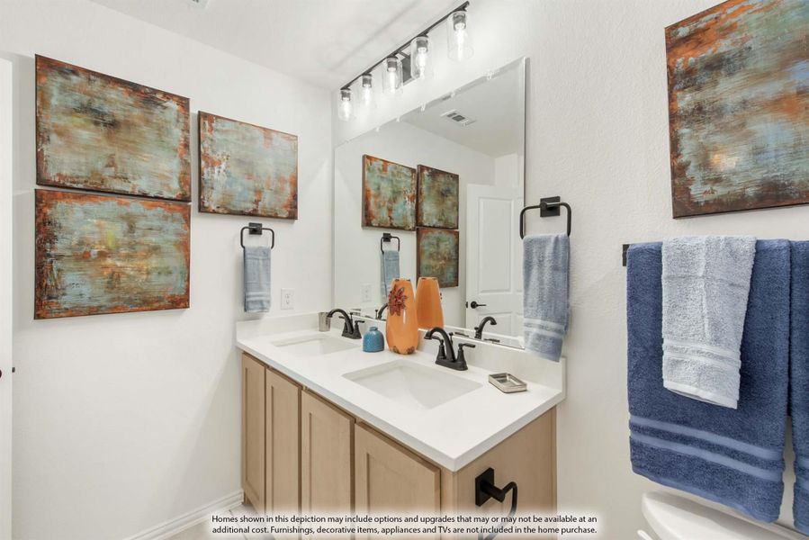 Bathroom with double-sink vanity, white countertop, large mirror, and abstract wall art