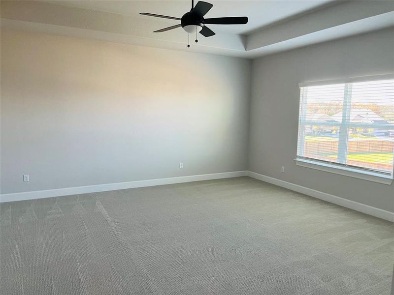 Spacious Master Bedroom with carpet, ceiling fan, and double window.