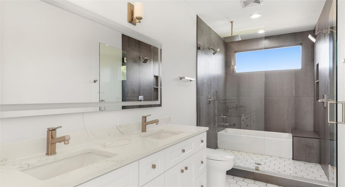 Full bath featuring walk in shower, double vanity, a tub to relax in, and light tile patterned floors