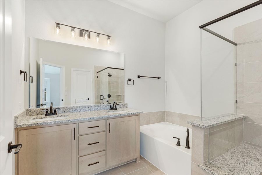 Master bathroom with double vanity, granite countertops, soaking tub, and glass walk-in shower with tile surround Master bathroom with double vanity, granite countertops, soaking tub, and glass walk-in shower with tile surround