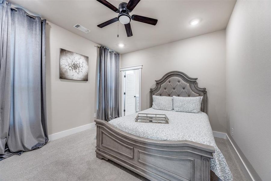 Bedroom with light carpet, ceiling fan, and recessed lighting