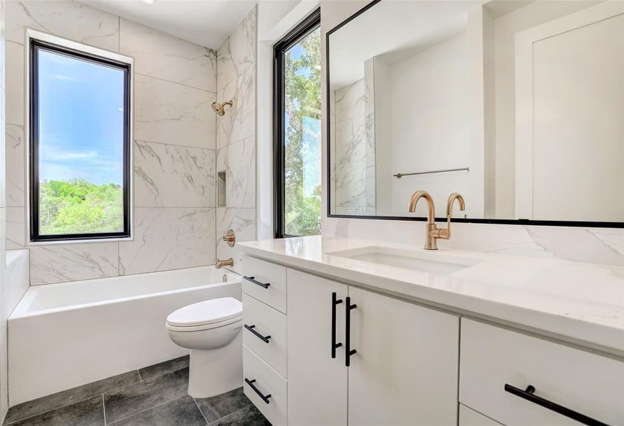 Full bath featuring vanity, healthy amount of natural light, toilet, and shower / bath combination