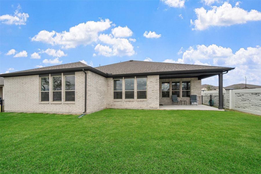 Rear view of home shows the brick and big windows offering natural light.