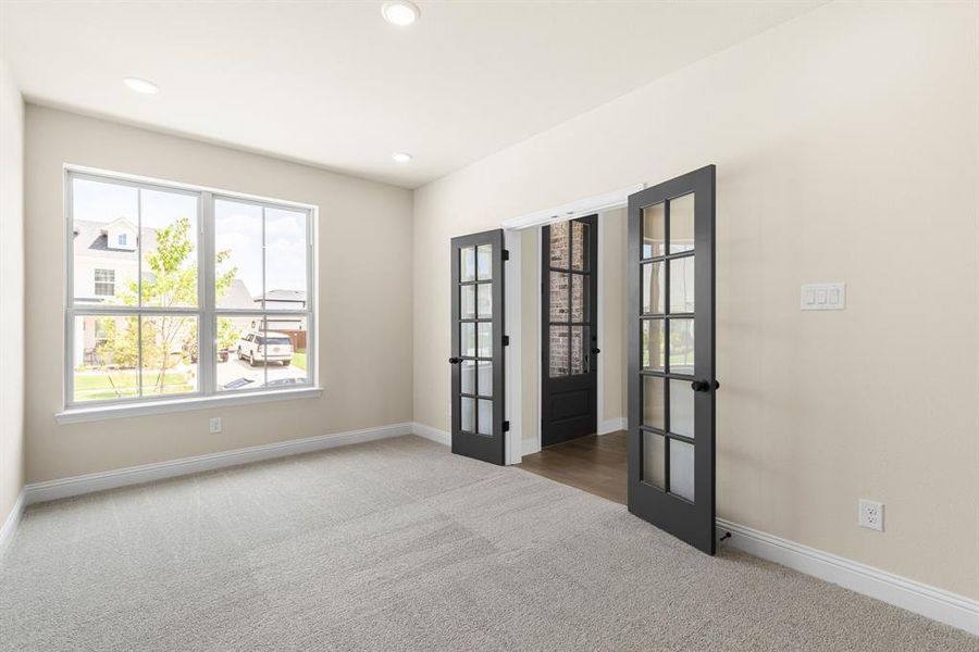 Carpeted empty room with french doors and a wealth of natural light