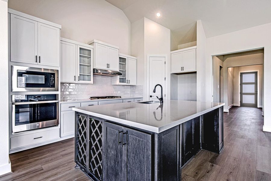 Enjoy preparing meals in the spacious kitchen featuring a large island, breakfast bar, modern finishes, and abundant workspace Enjoy preparing meals in the spacious kitchen featuring a large island, breakfast bar, modern finishes, and abundant workspace
