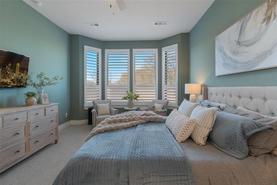 Bedroom with light carpet, baseboards, visible vents, and a ceiling fan