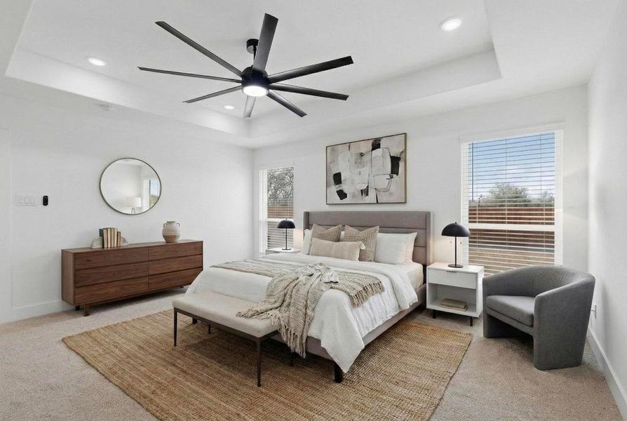 Bedroom with light colored carpet, ceiling fan, recessed lighting, and a tray ceiling