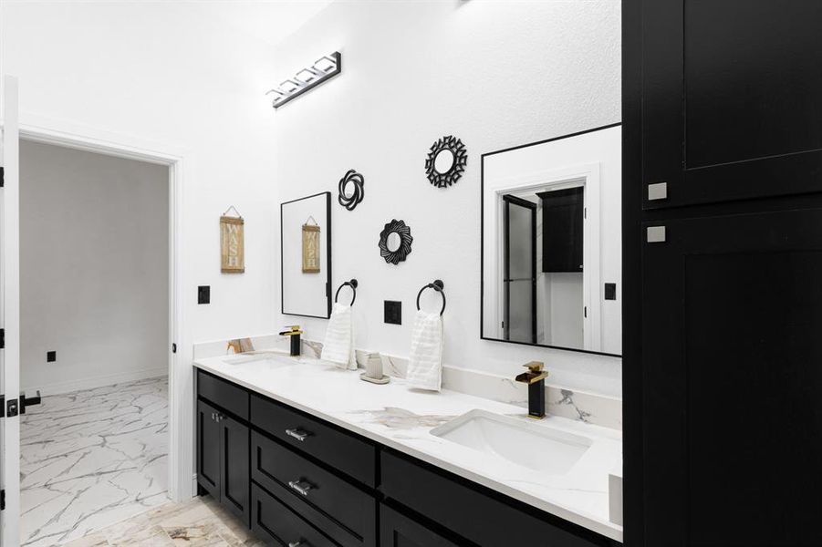Bathroom featuring light marble finish flooring and double vanity