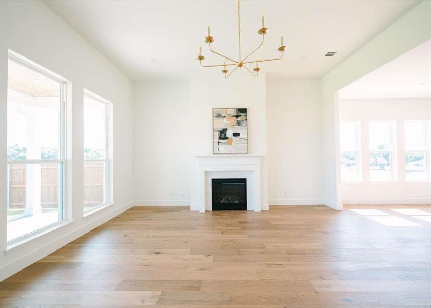 Unfurnished living room with a notable chandelier and light hardwood / wood-style flooring