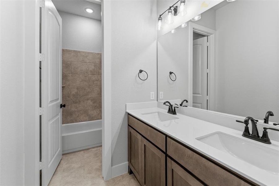 Bathroom featuring a dual vanity with white countertops, undermount sinks, and matte black fixtures