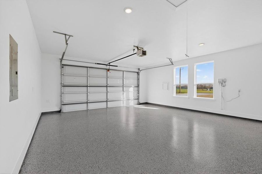 Garage featuring electric panel and baseboards Garage featuring electric panel and baseboards