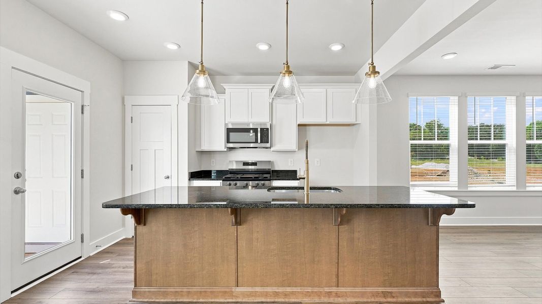 Highly skilled craftsmanship shines in this modern kitchen with pendant lighting and a central island focal point in SC Highly skilled craftsmanship shines in this modern kitchen with pendant lighting and a central island focal point in SC