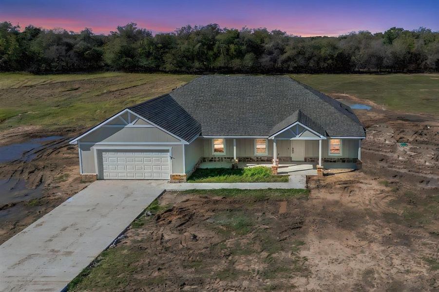 View of front of property featuring covered porch and a garage