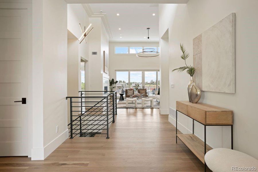 Light-toned modern hardwood floors create a warm, seamless flow through the airy, contemporary entry.