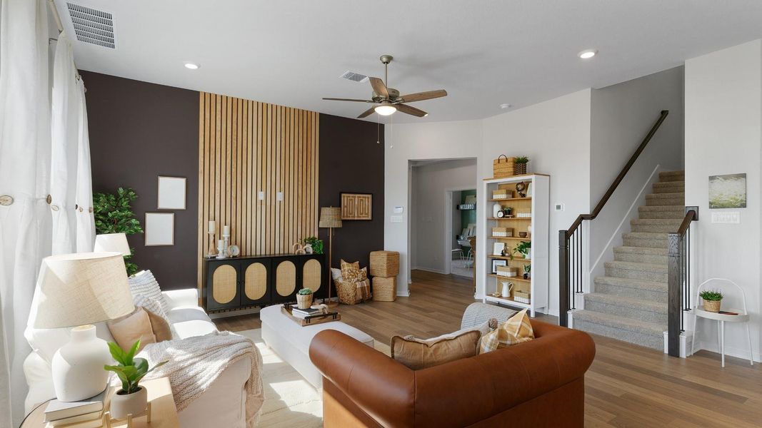 Natural light floods this inviting living area, showcasing rich hardwood floors and a striking accent wall. Natural light floods this inviting living area, showcasing rich hardwood floors and a striking accent wall.