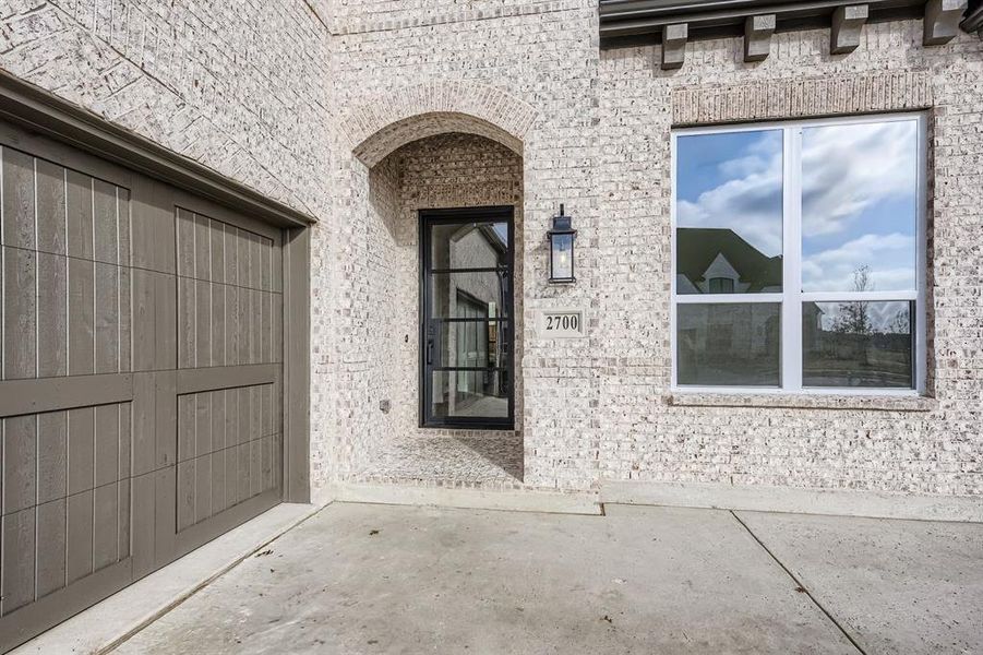 Property entrance featuring brick siding and a patio