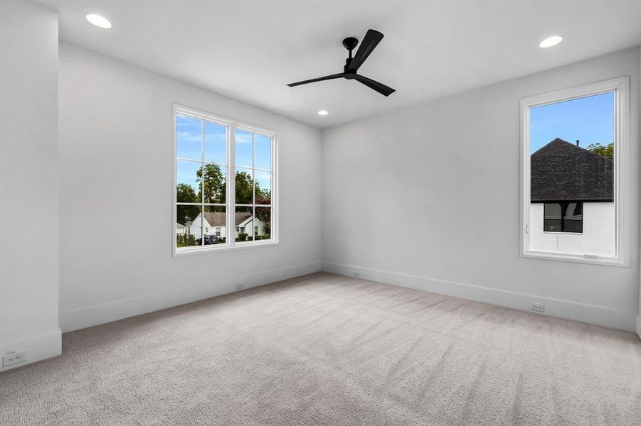 Unfurnished room featuring light colored carpet and ceiling fan