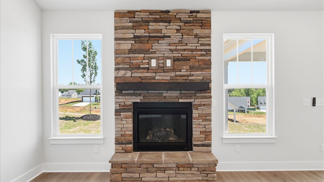 A beautifully designed stone fireplace brings warmth and character to this inviting living space at Iris Meadows