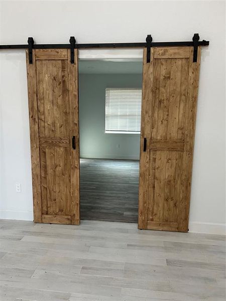 study/office entrance with rustic sliding doors, matching the high ceiling cedar beams in the den