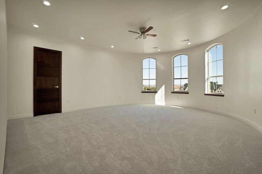 Carpeted spare room featuring ceiling fan