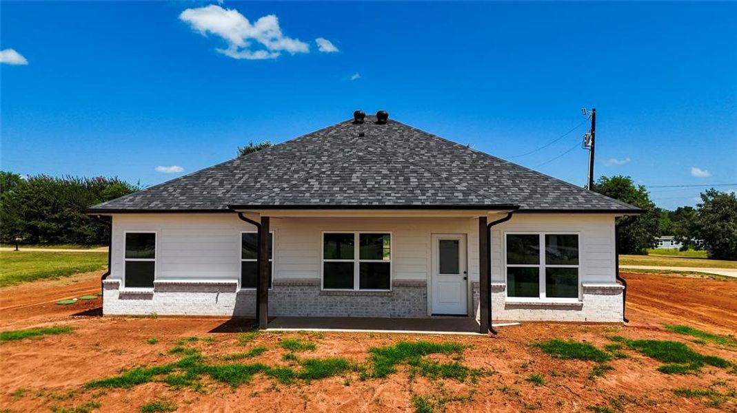 Rear view of house featuring roof with shingles and a patio Rear view of house featuring roof with shingles and a patio