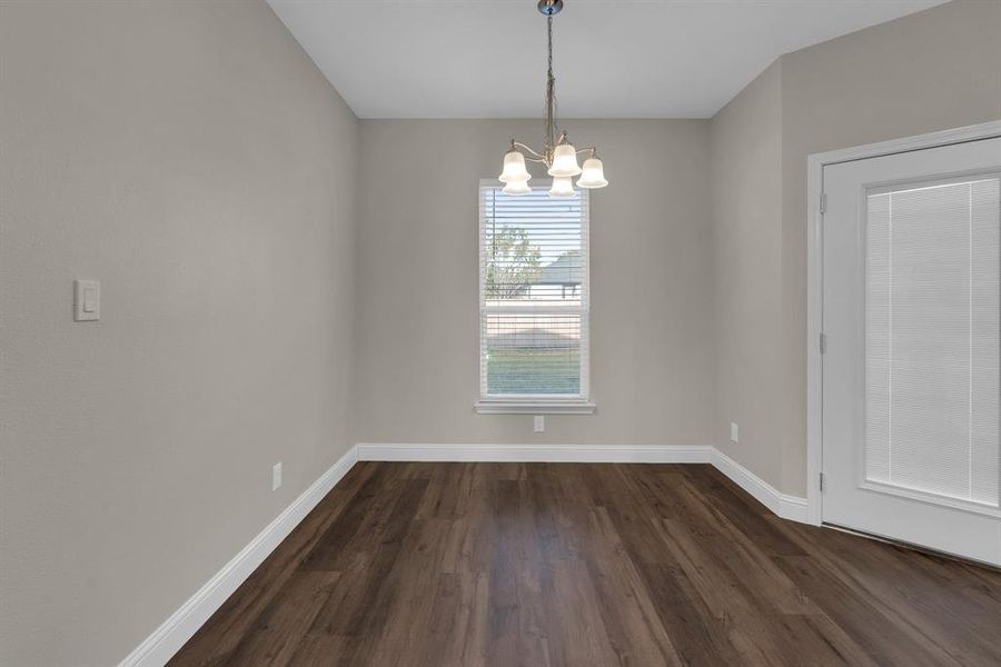 Dinning area with a chandelier and dark hardwood / wood-style floors