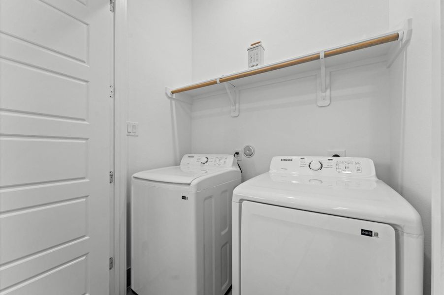 Located just steps from the primary bedroom, this second-floor laundry area offers everyday ease with a smart, accessible layout. Featuring space for full-size appliances, shelving and hanging space, it is perfectly positioned for comfort and efficiency in a busy household.