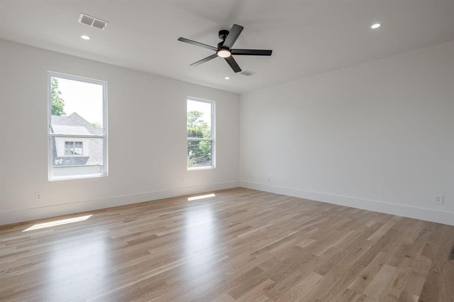 Empty room with light wood finished floors, recessed lighting, and a ceiling fan Empty room with light wood finished floors, recessed lighting, and a ceiling fan