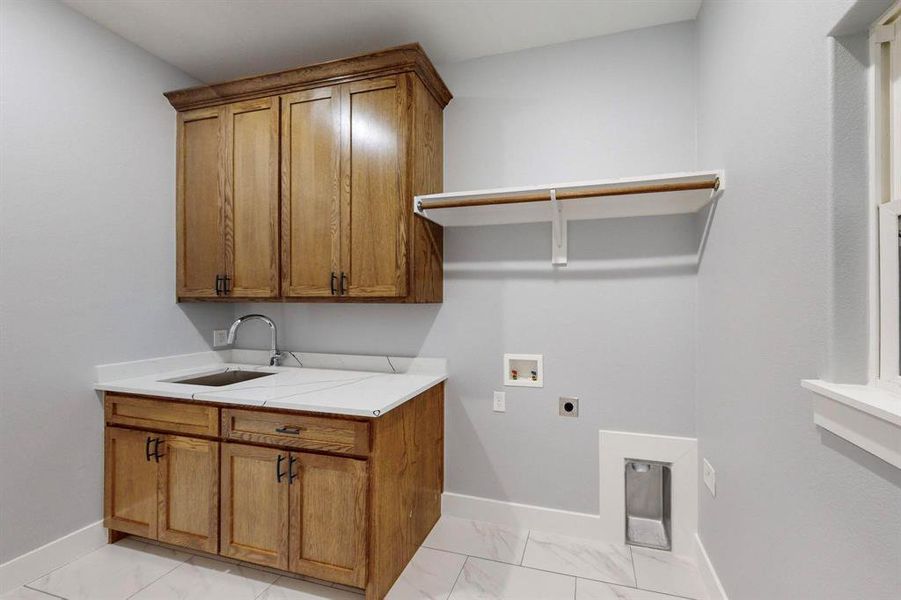 Laundry area featuring hookup for an electric dryer, hookup for a washing machine, cabinets, and sink