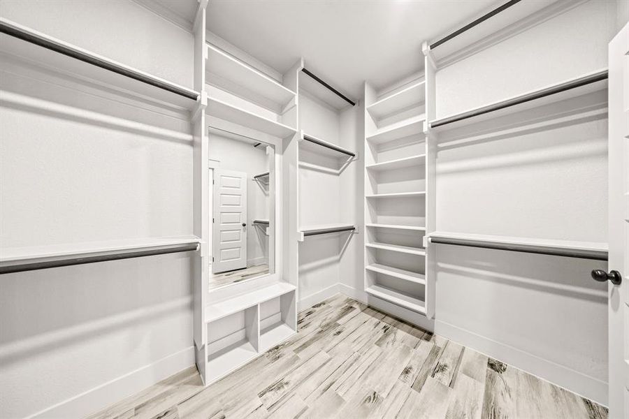 Spacious closet with light wood-style flooring Spacious closet with light wood-style flooring
