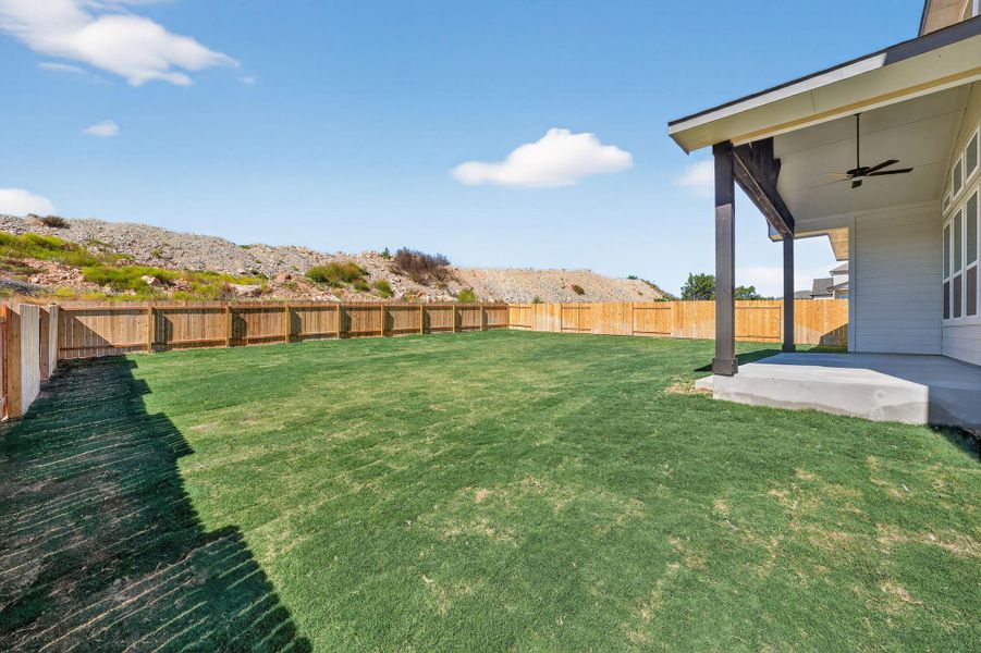 Fenced backyard featuring ceiling fan and a patio area Fenced backyard featuring ceiling fan and a patio area
