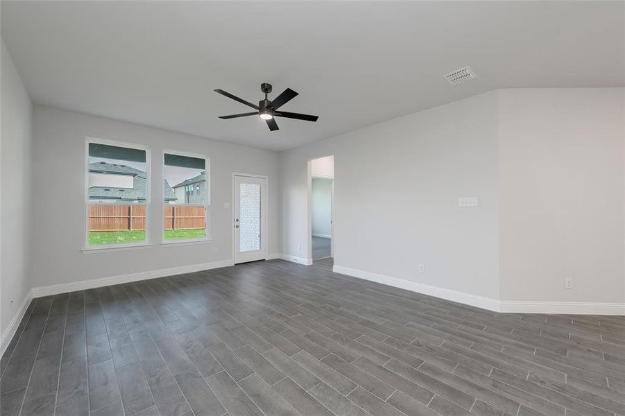Spare room featuring ceiling fan, baseboards, and dark wood-style flooring Spare room featuring ceiling fan, baseboards, and dark wood-style flooring