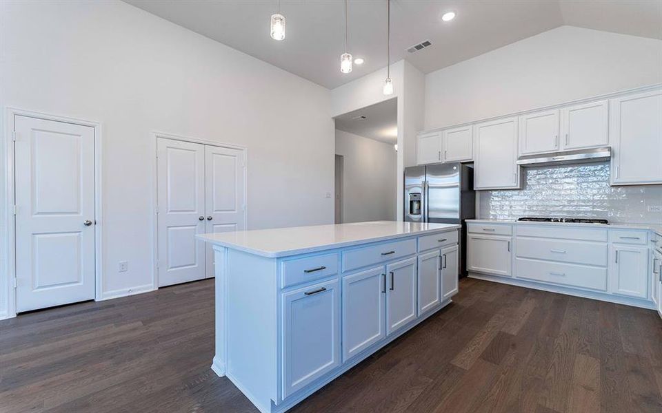 Kitchen featuring a central island with white cabinetry and a light-toned countertop