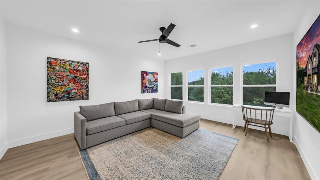 Living room featuring light wood finished floors, ceiling fan, baseboards, and recessed lighting Living room featuring light wood finished floors, ceiling fan, baseboards, and recessed lighting
