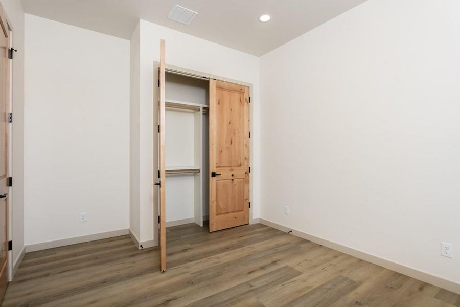 Unfurnished bedroom featuring a closet, wood finished floors, and recessed lighting Unfurnished bedroom featuring a closet, wood finished floors, and recessed lighting