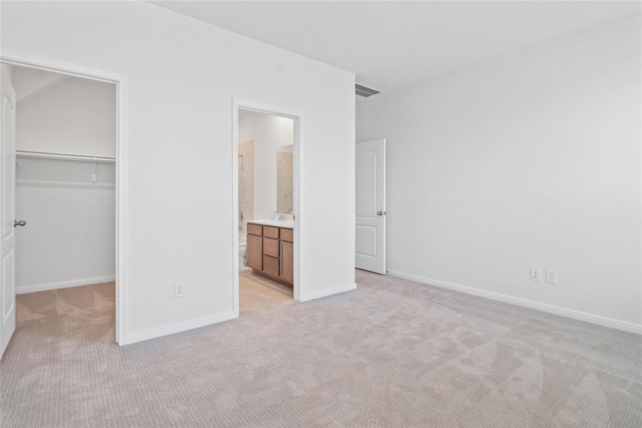The primary suite's walk-in closet and ensuite bathroom. The primary suite's walk-in closet and ensuite bathroom.