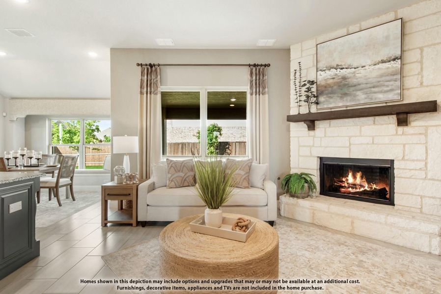 Open living room with stone fireplace, white sofa, and round woven coffee table, open to dining area