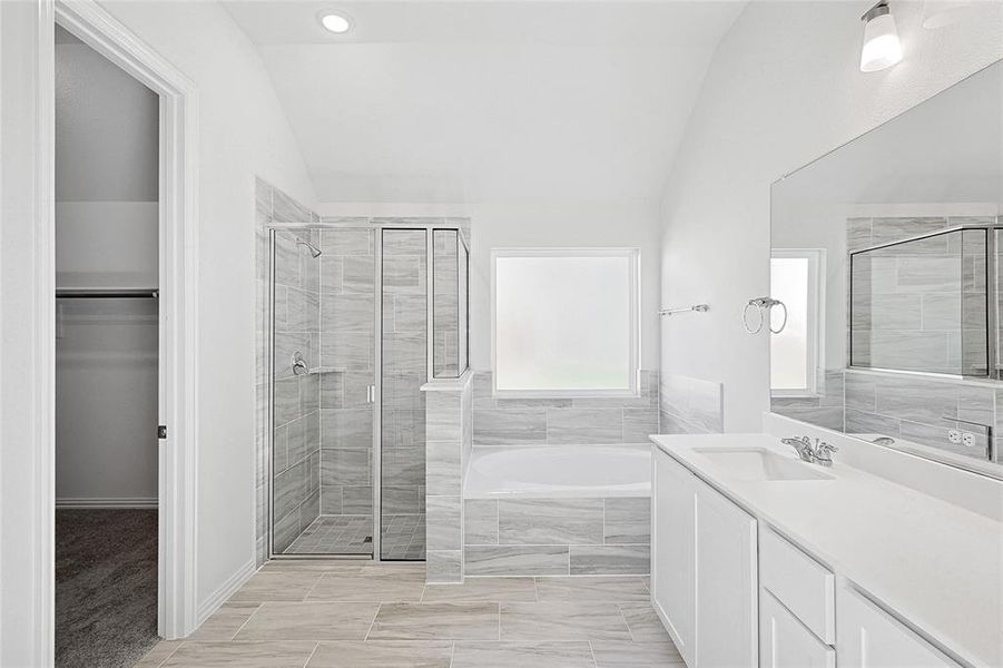 Bathroom with separate shower and tub, vanity, and vaulted ceiling