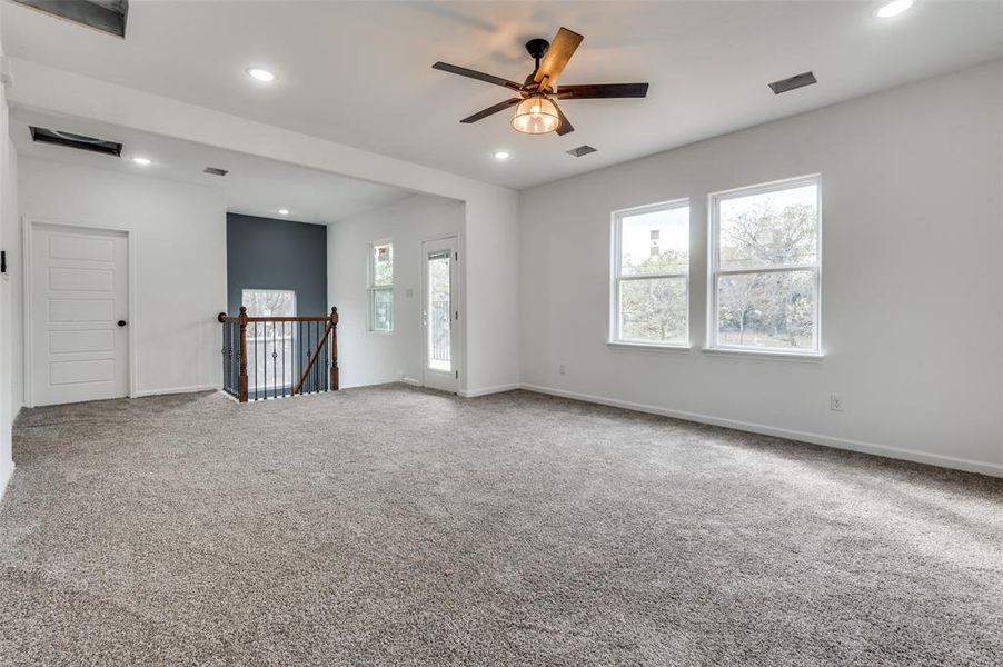 Unfurnished room with carpet flooring, ceiling fan, and a healthy amount of sunlight