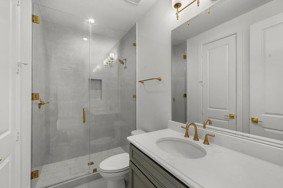 The secondary bath features tile flooring, custom stained cabinetry and light countertops and a walk-in shower. Perfect for accommodating any visiting family and friends. The secondary bath features tile flooring, custom stained cabinetry and light countertops and a walk-in shower. Perfect for accommodating any visiting family and friends.