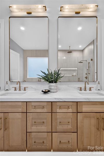 2" Calcutta quartz, dual sink vanities with Champagne bronze fixtures, pulls and lighting. Closet to the left, water closet to the right.