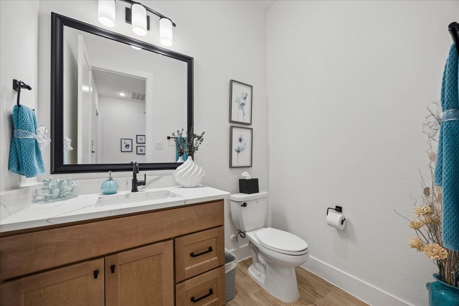 Full view of powder bathroom with custom soft close cabinets and granite countertops.