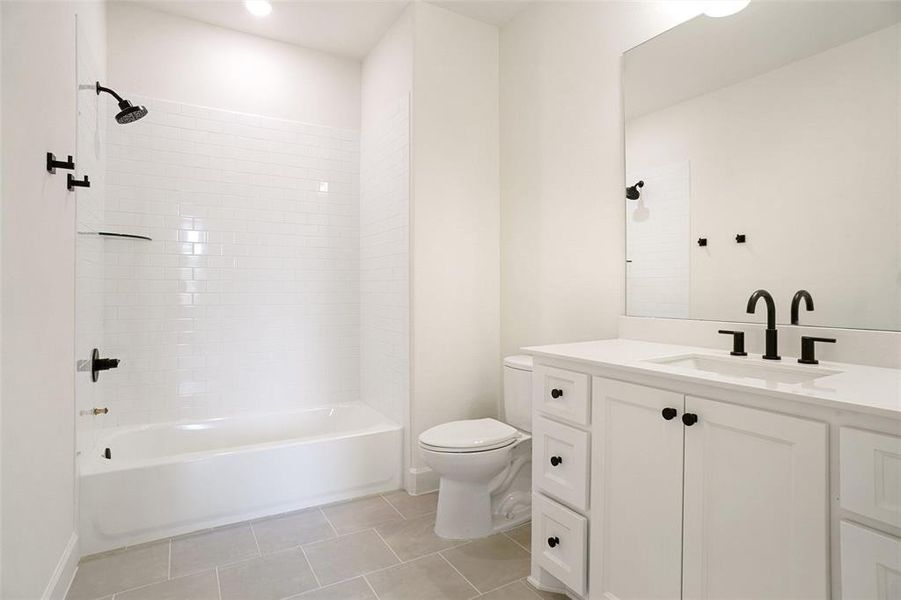 Bathroom with vanity, washtub / shower combination, and tile patterned flooring Bathroom with vanity, washtub / shower combination, and tile patterned flooring