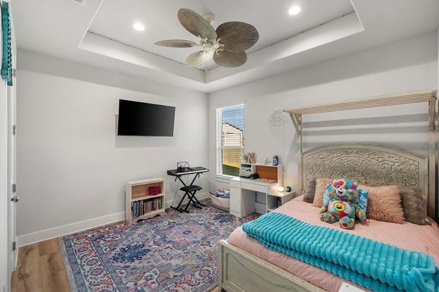 Bedroom featuring a tray ceiling, wood finished floors, ceiling fan, and recessed lighting