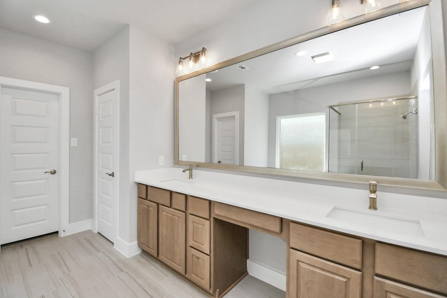 Escape to a spa-like oasis in this primary bathroom. Enjoy a walk-in shower with tile surround, a separate garden tub with custom detailing, and an elegant vanity featuring light countertops, modern hardware, and beautiful recessed and vanity lights. Experience luxury and relaxation in every detail. Sample photo of completed home with similar floor plan. Actual colors and selections may vary. Escape to a spa-like oasis in this primary bathroom. Enjoy a walk-in shower with tile surround, a separate garden tub with custom detailing, and an elegant vanity featuring light countertops, modern hardware, and beautiful recessed and vanity lights. Experience luxury and relaxation in every detail. Sample photo of completed home with similar floor plan. Actual colors and selections may vary.