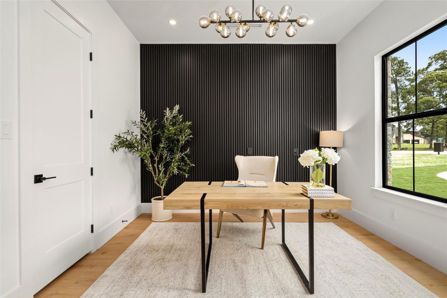Main-level study/home office with a custom accent wall, modern lighting, and French doors. Main-level study/home office with a custom accent wall, modern lighting, and French doors.