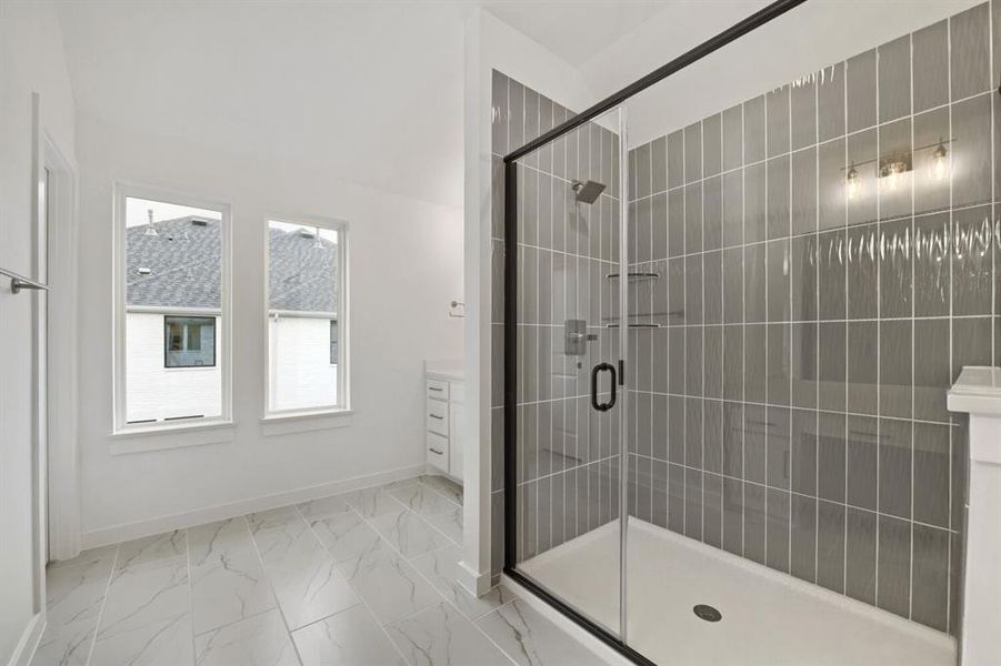 Spacious bathroom featuring a frameless glass shower enclosure with matte black accents, vertical gray subway tile, and a built-in shower bench Spacious bathroom featuring a frameless glass shower enclosure with matte black accents, vertical gray subway tile, and a built-in shower bench