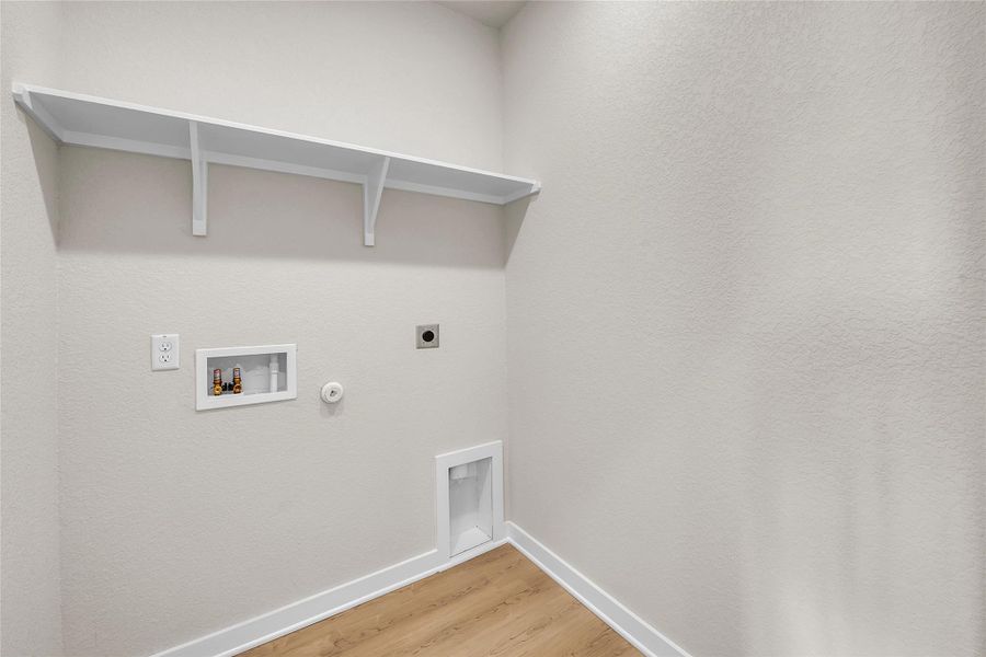 Washroom featuring gas dryer hookup, light wood-style flooring, electric dryer hookup, and hookup for a washing machine